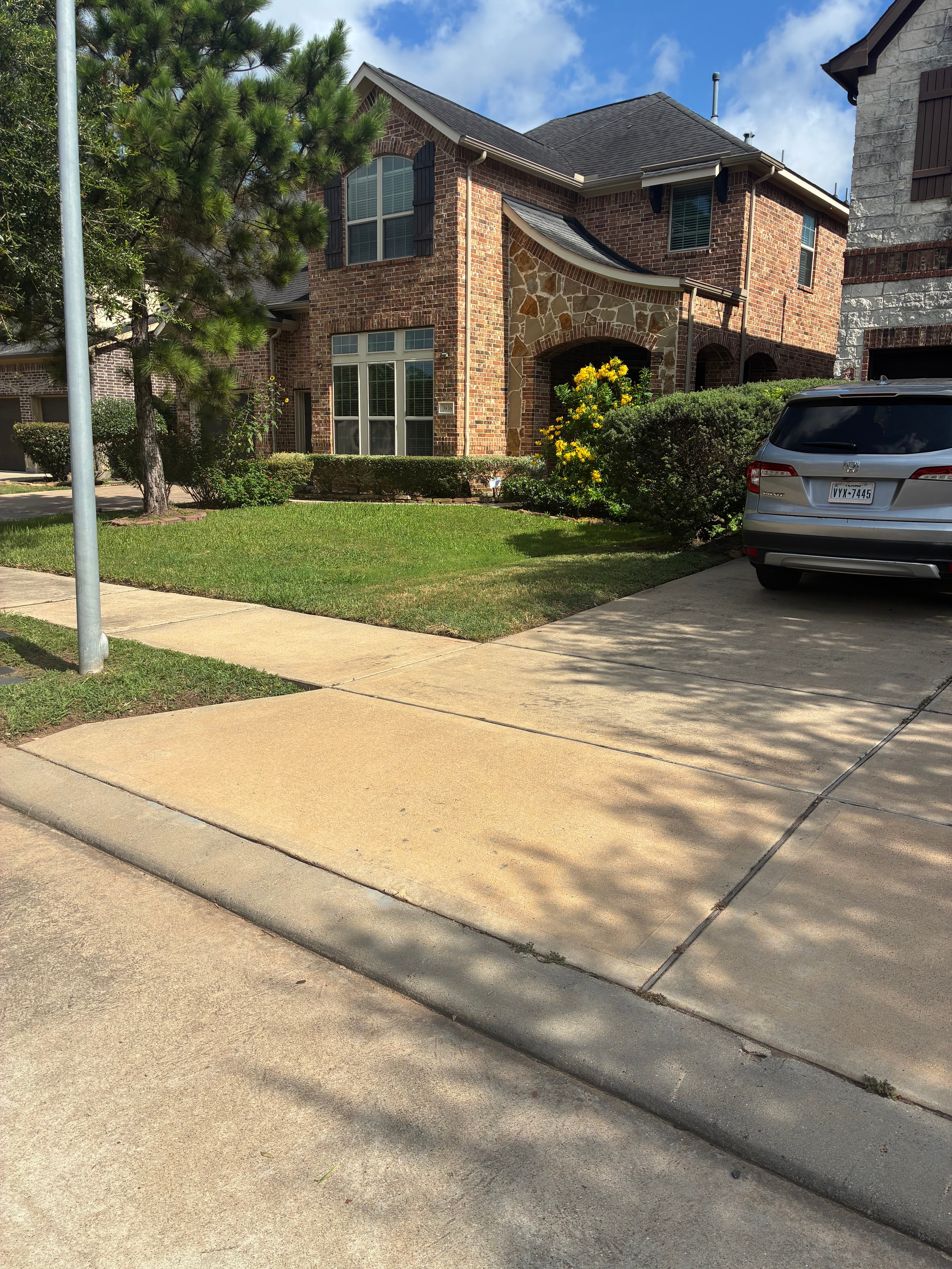 Brick home with clean edged lawn and yellow flowering shrubs