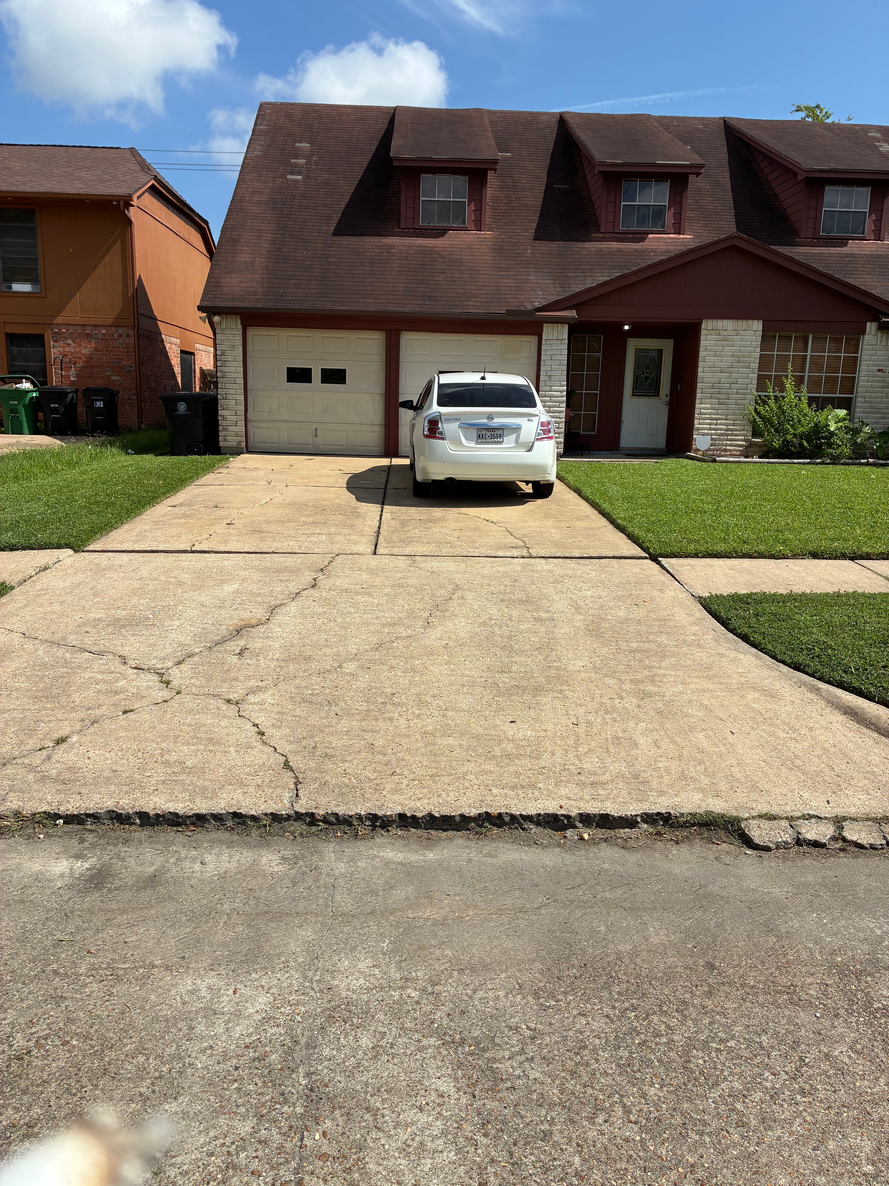 Brick home with neatly mowed front lawn and clean driveway