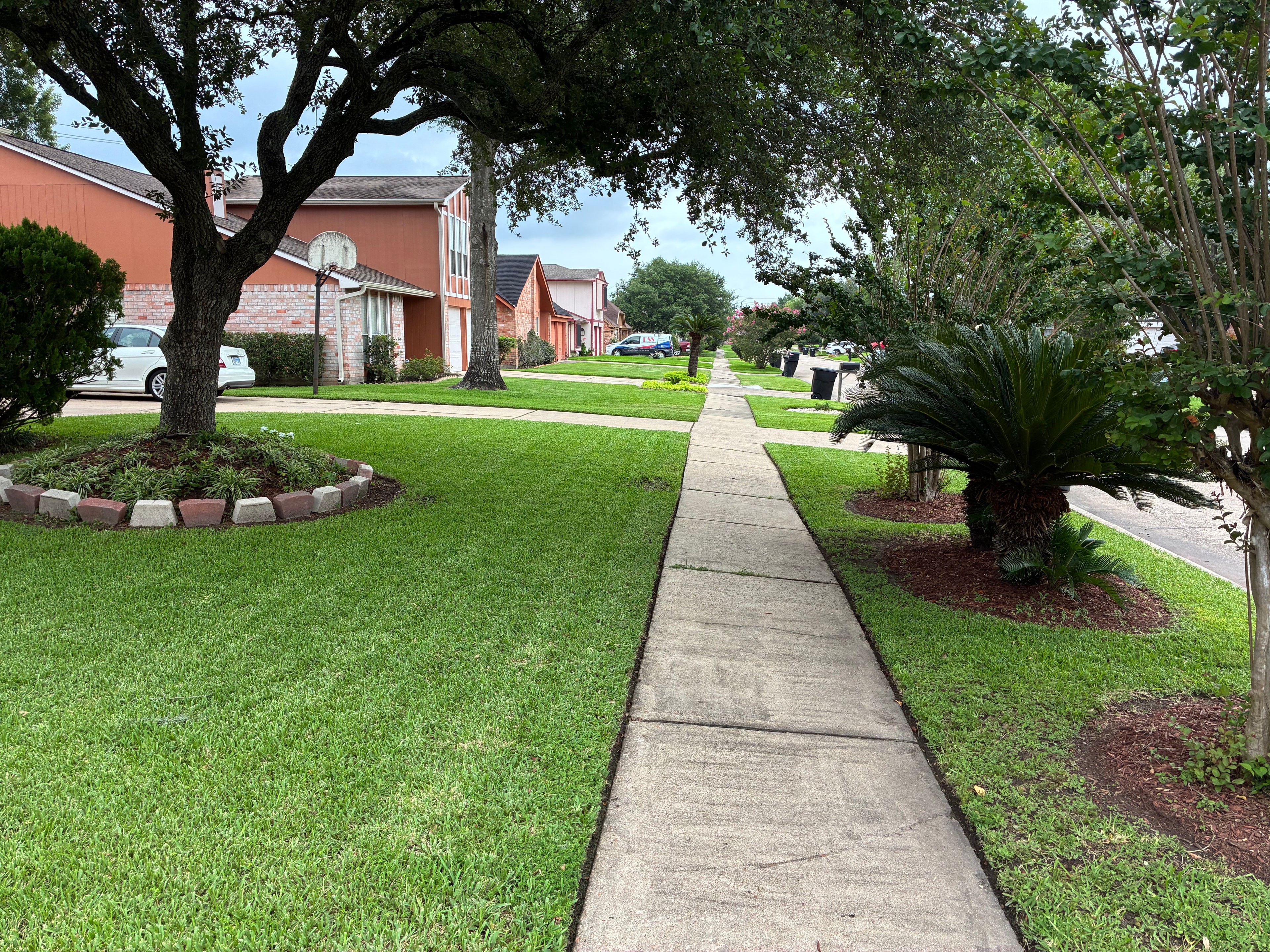 Perfectly mowed front yard with curved driveway edge and red door