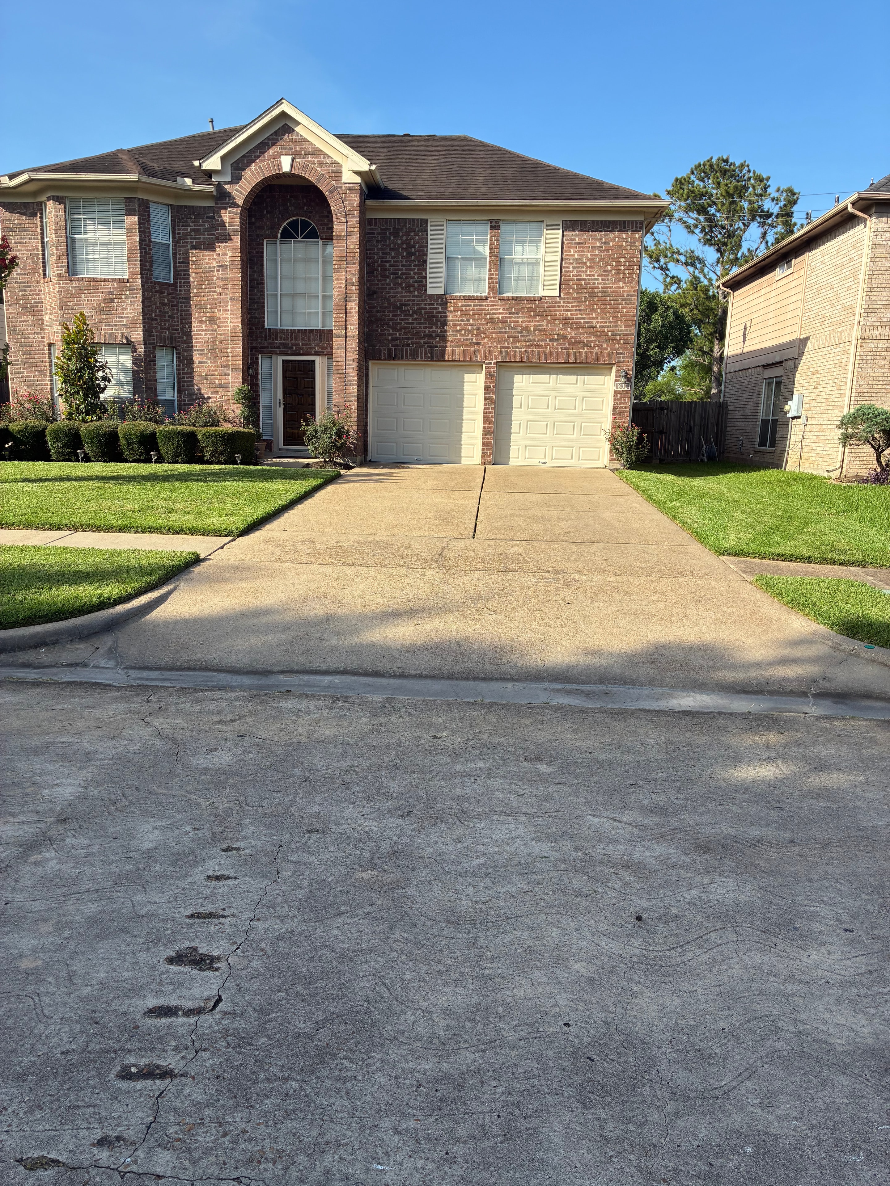 Clean mowed lawn with manicured hedges and tidy driveway