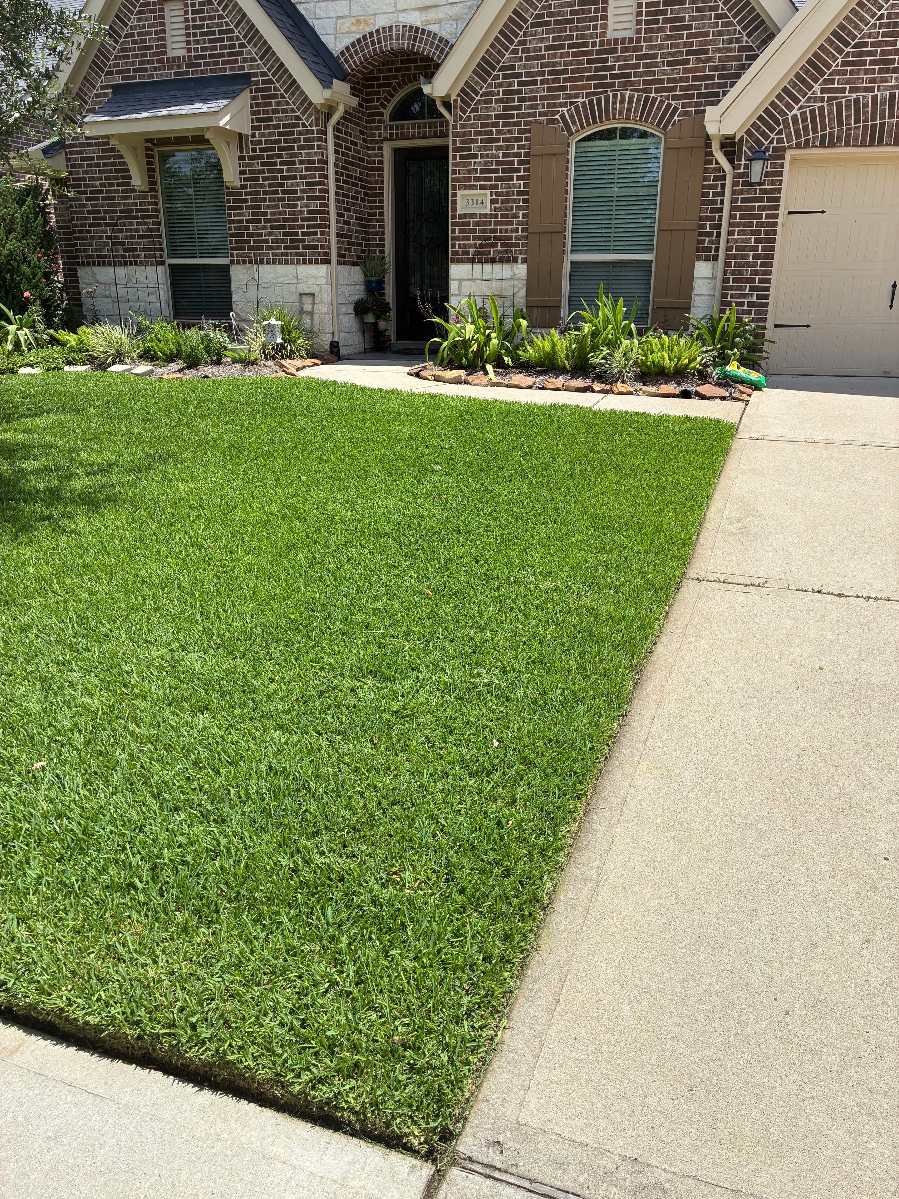 Perfectly mowed front yard with clean driveway edge